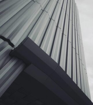 Low angle shot of a modern building with gray tones and overcast sky, emphasizing architectural lines. {{brizy_dc_image_alt imageSrc=