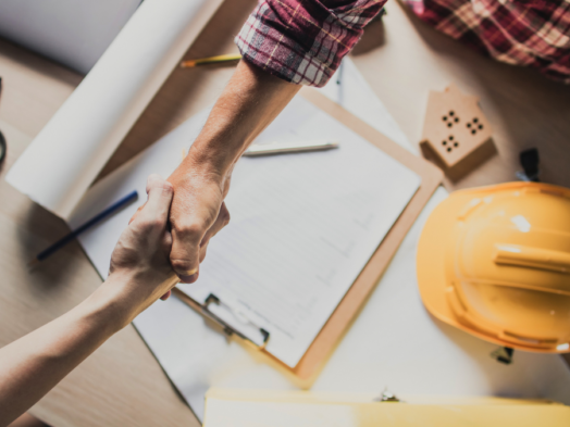 Two people shaking hands agreeing an a roofing contractor to preform roofing work.